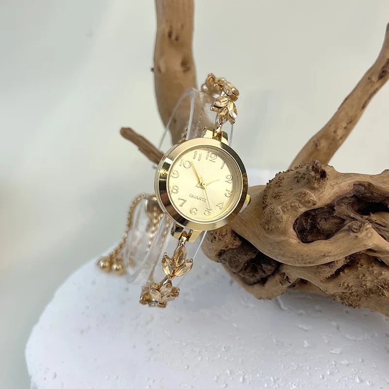 Montre élégante pour femme à quartz : boîtier rond en alliage, cadran classique à chiffres arabes, bracelet tendance orné de diamants et aiguilles en forme de feuille.